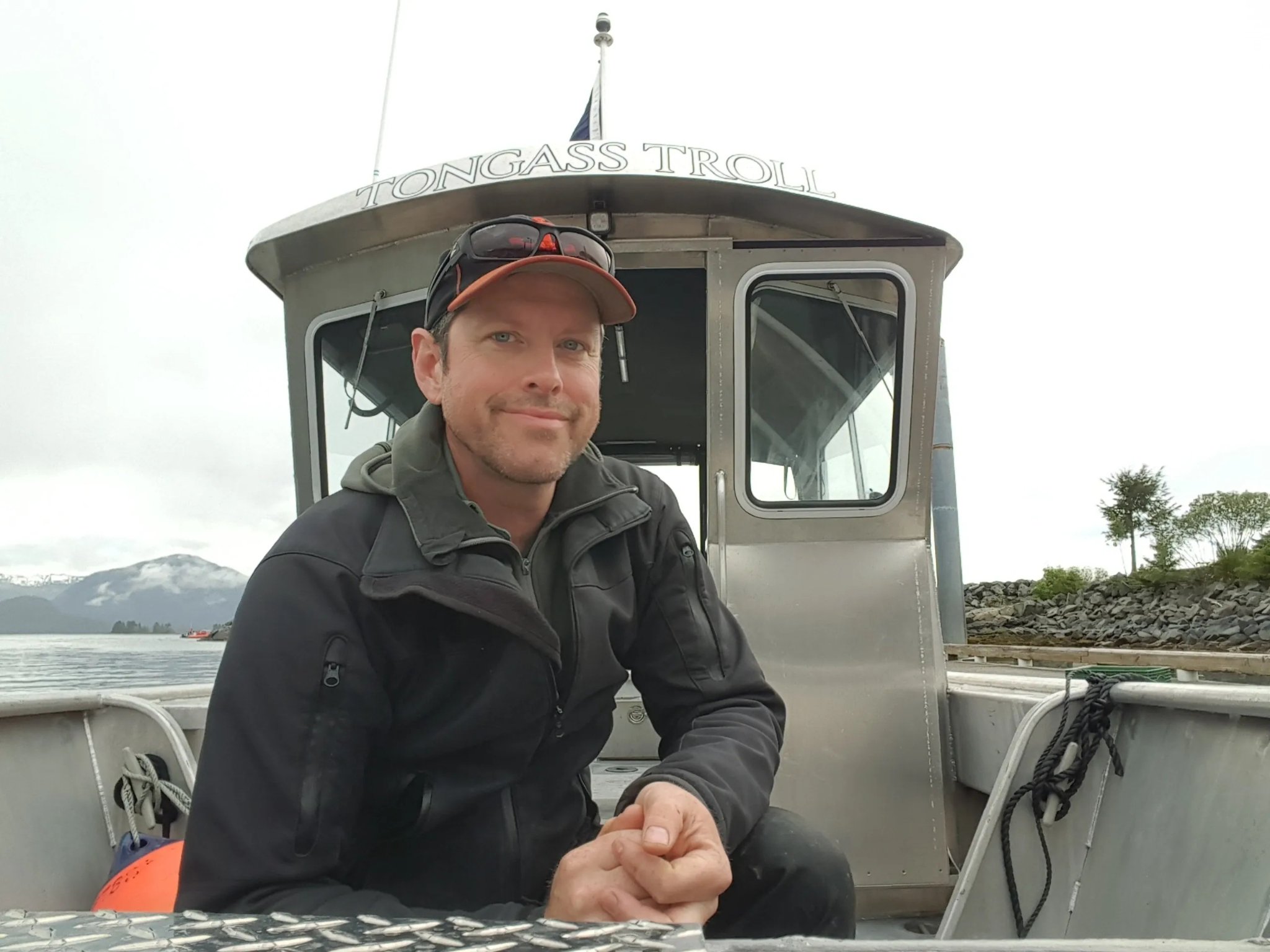 Happy family of four guests inside the cabin of the Tongass Troll on a rainy day