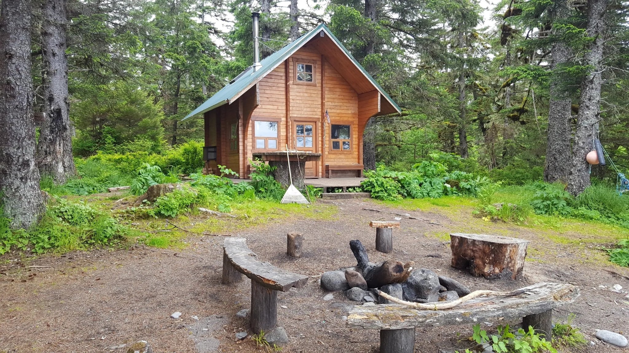 Remote Forest Service cabin with fire pit surrounded by Sitka spruce