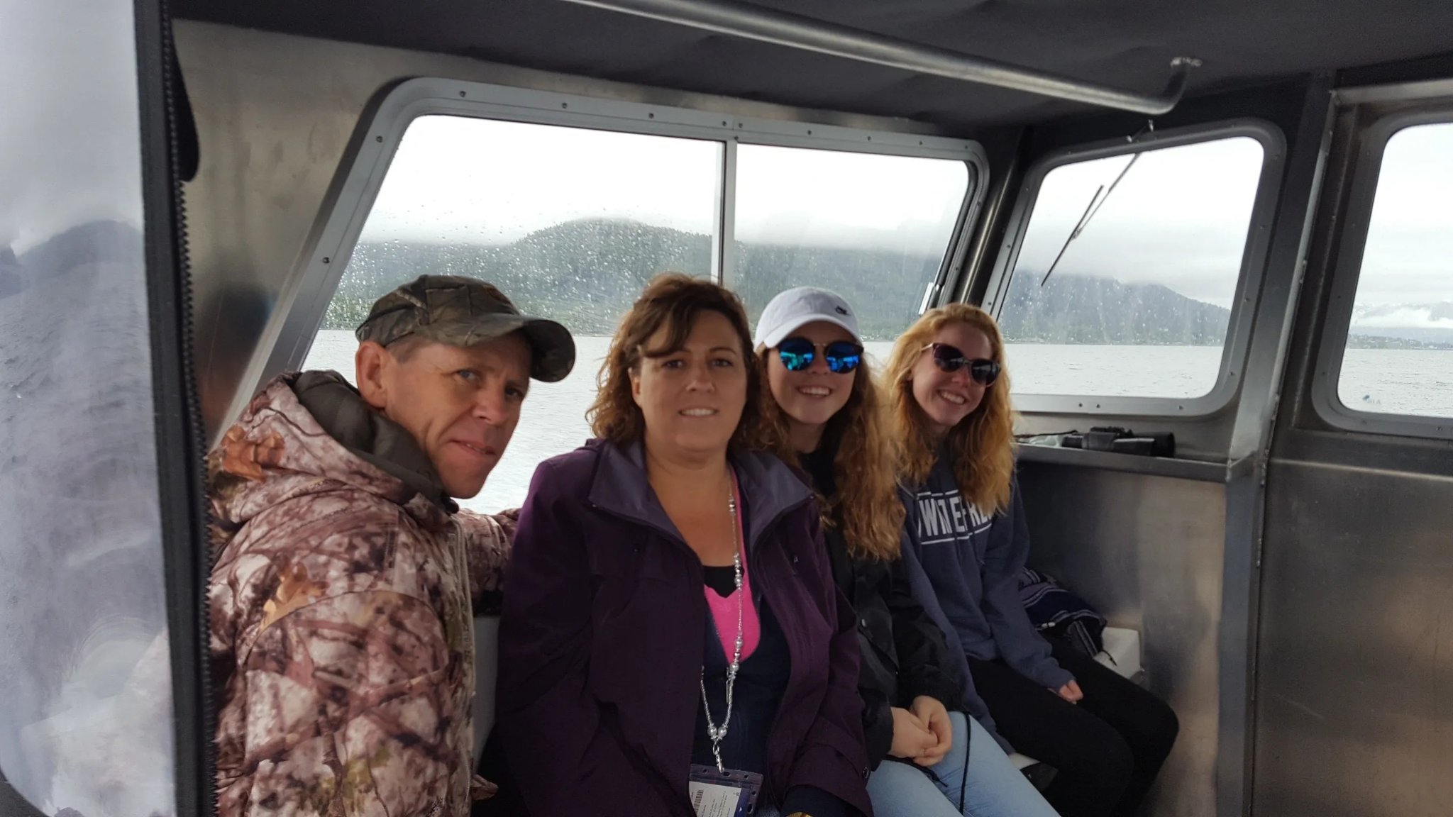 Capt. Xander seated at the stern of the Tongass Troll, Sitka harbor behind him